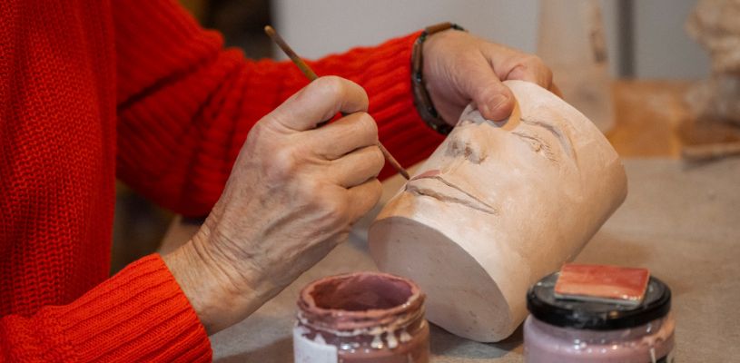 Manos trabajando los detalles de una pieza de cerámica en el Atelier de Balmori, en Llanes, Asturias